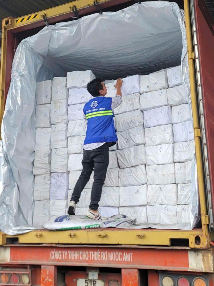 Charcoal bales being loaded and secured inside a container