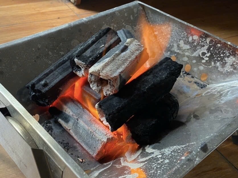 Sawdust Ogatan briquettes burning in a grill